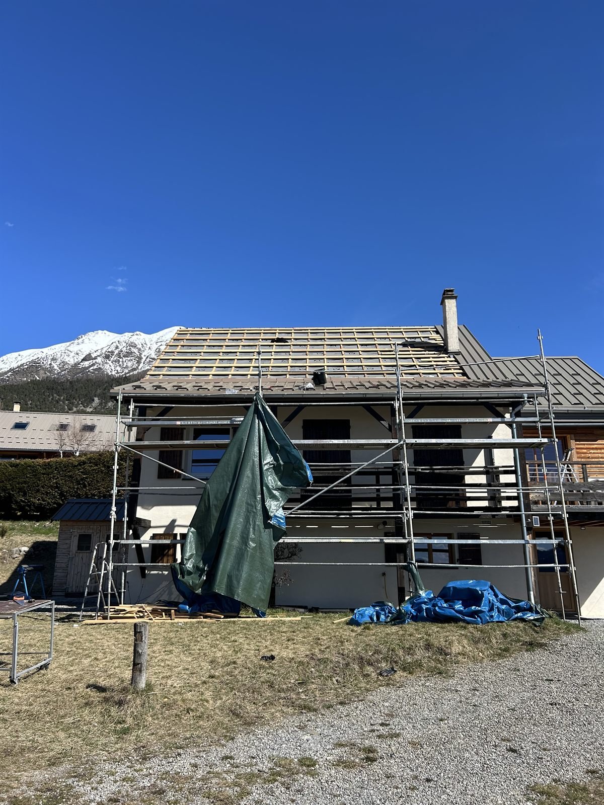 Réfection de toiture d'un chalet par S.J Couverture, face aux montagnes enneigées des Hautes-Alpes